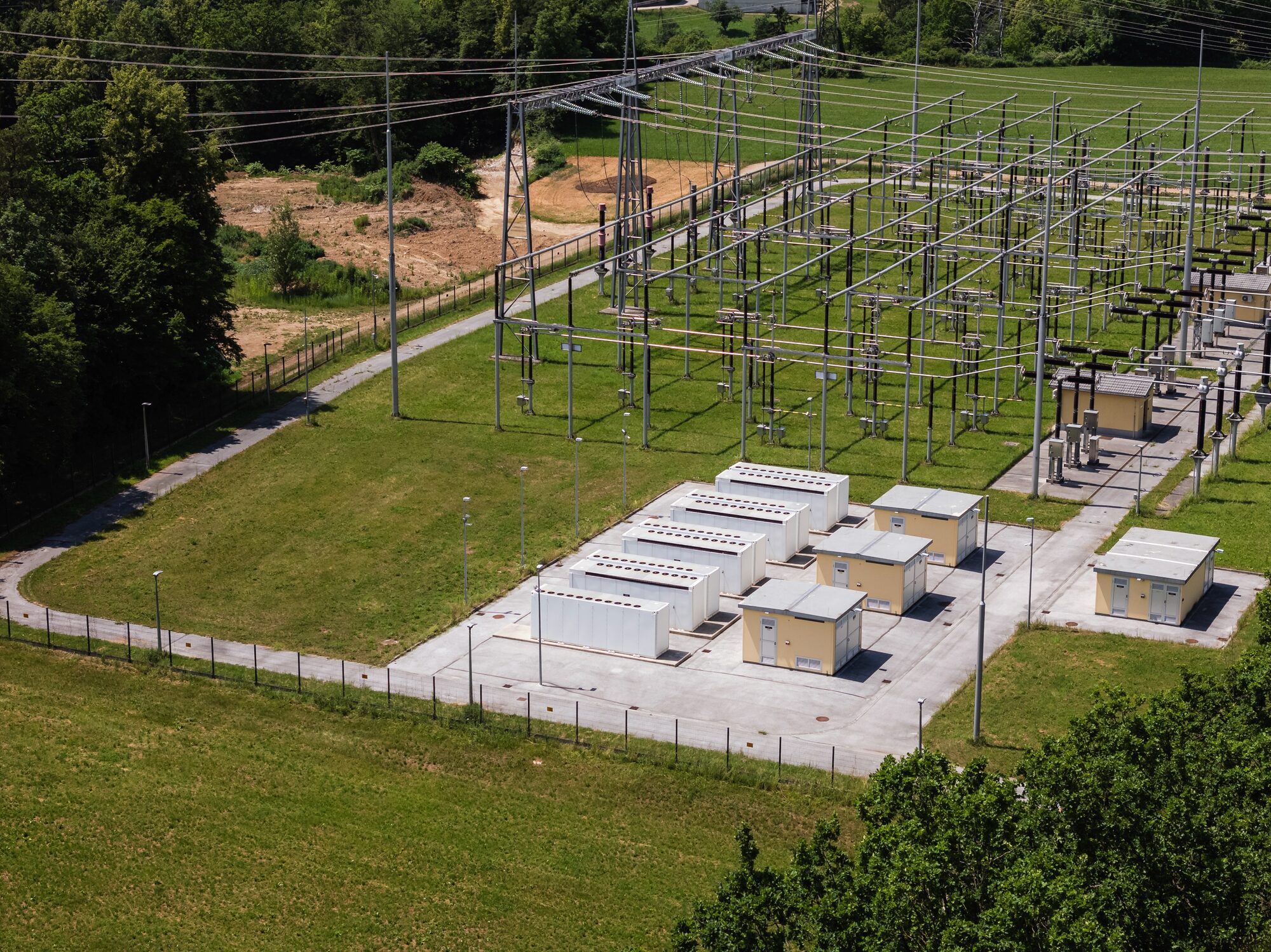 Battery containers integrated into the switchyard of an electrical substation